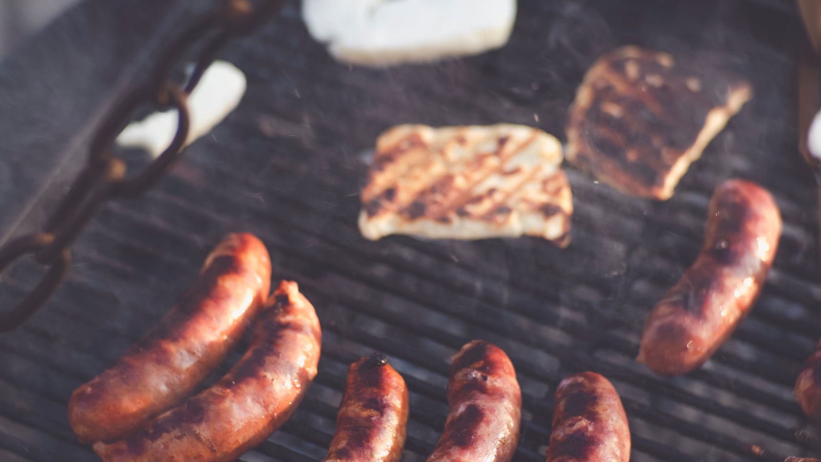 Sausages and meat grilling on a backyard barbecue