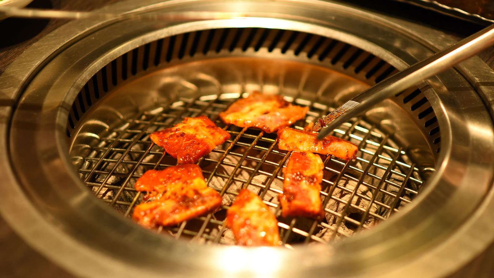 Marinated pork on a round tabletop Korean BBQ grill
